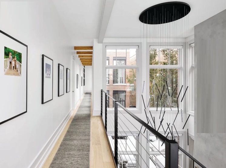 A custom runner by Oscar Isberian Rugs and Chute multi light chandelier by Kuzco Lighting sourced at Lightology make the second-floor hallway someplace worth lingering Photographed by Dustin Halleck