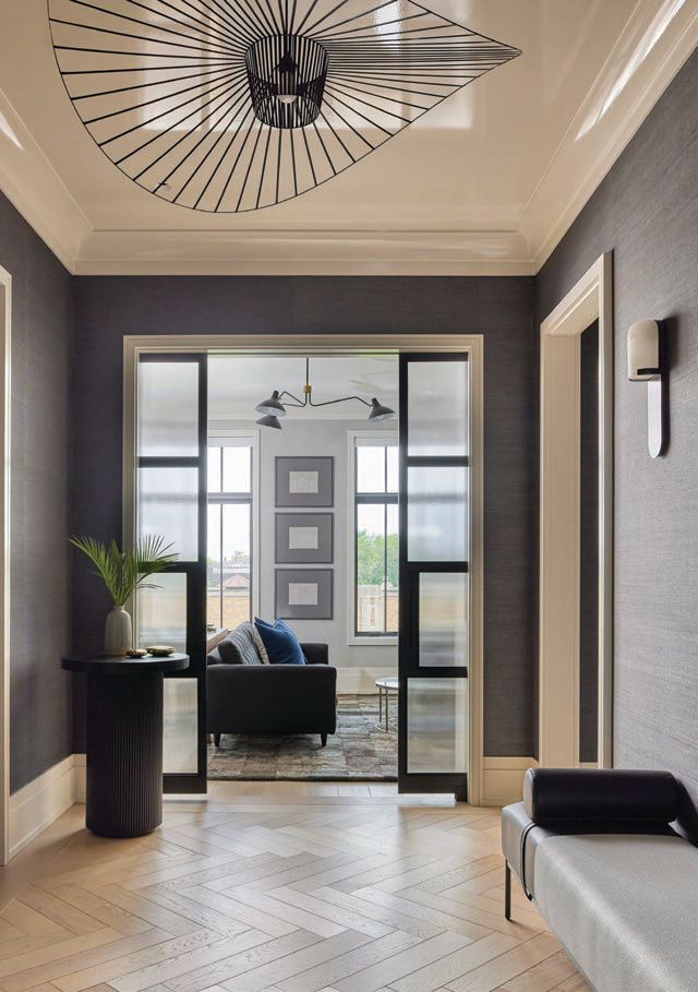 The inviting entry features Vertigo pendant lighting by Petite Friture, sisal wallcovering by Schumacher and Northern Wide Plank flooring. Photographed by Mike Schwartz