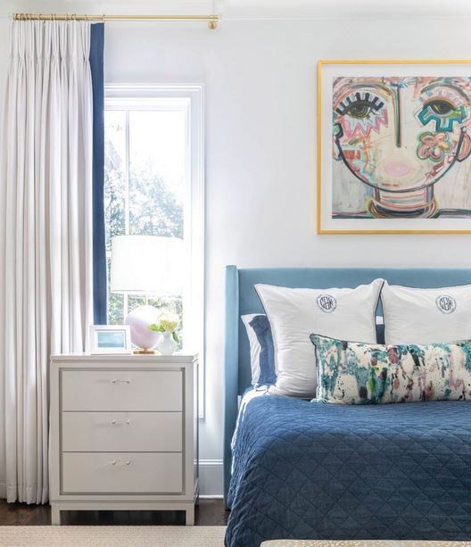 Artwork by Windy O’Connor hangs above the primary bed with bedside tables by Slate Interiors. Photographed by Heidi Harris Photography