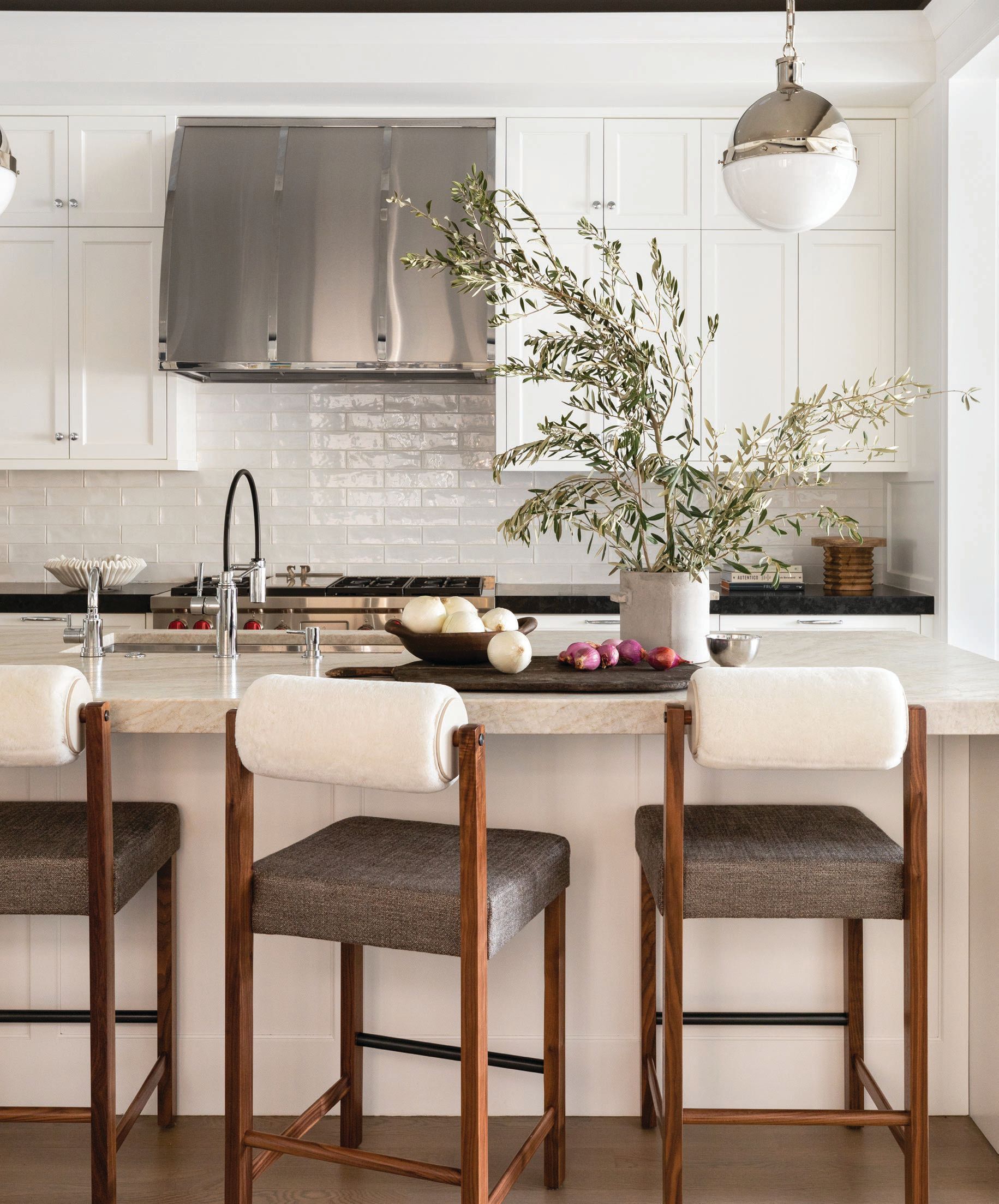 Inviting counter stools by Thomas Hayes Studio add a soft touch to the sleek kitchen. Photographed by Aimée Mazzenga