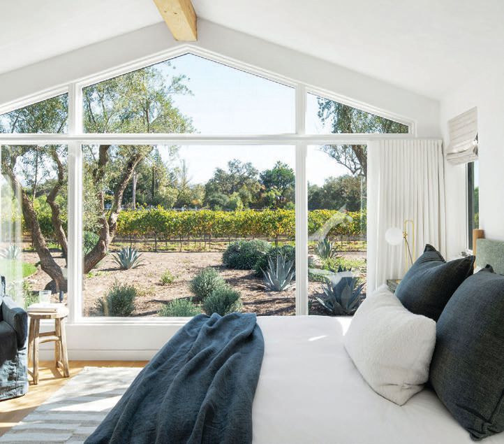 A bedroom in the guesthouse frames an idyllic vineyard view. PHOTOGRAPHED BY GAVIN CATER