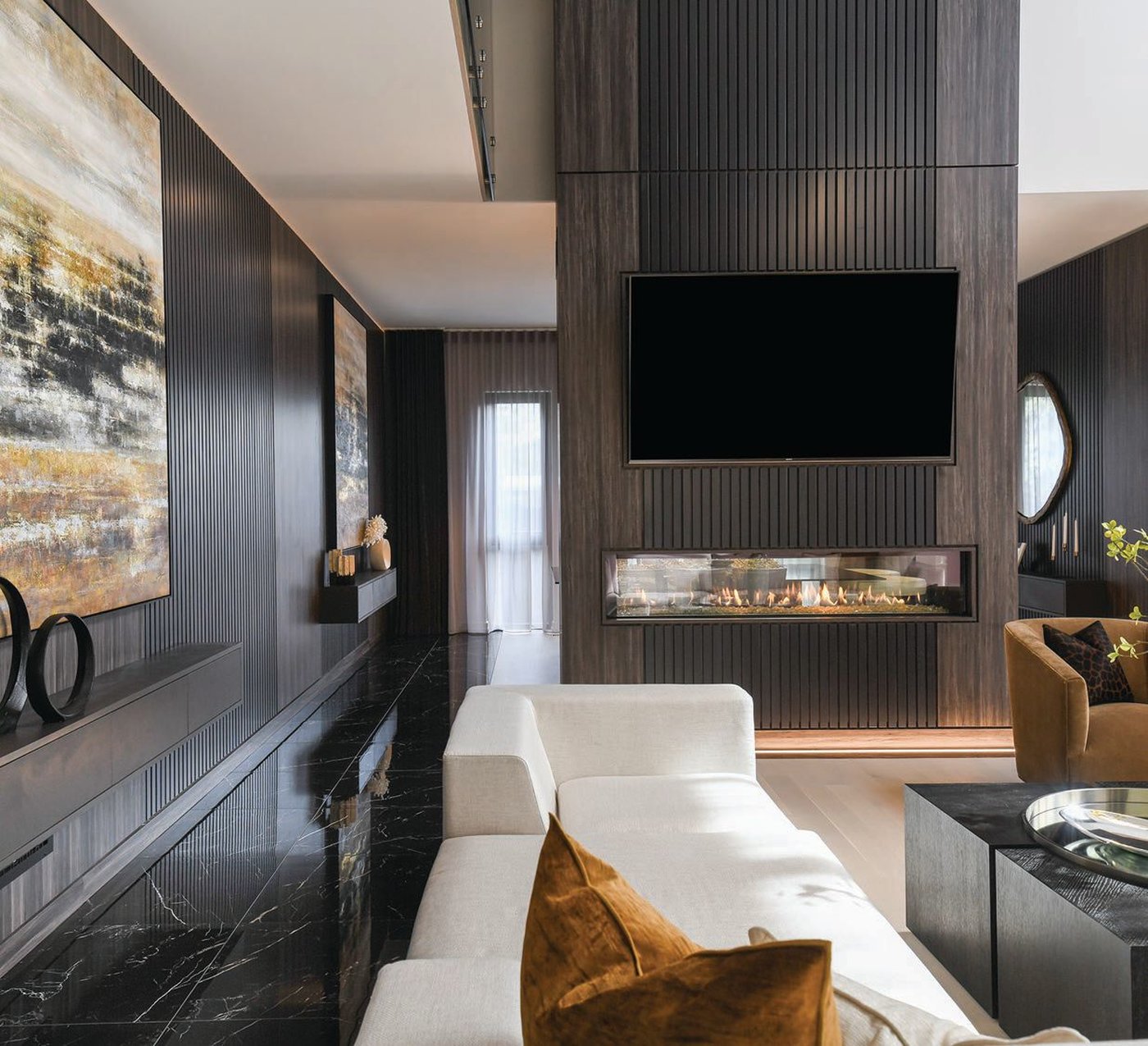 The great room, clad in smoky tones and metallic finishes, is complemented by a combination of four sleek chandeliers from ET2 Contemporary Lighting. PHOTO BY ANGELIKA FRIDAY/CHIC-INTERIOR.COM