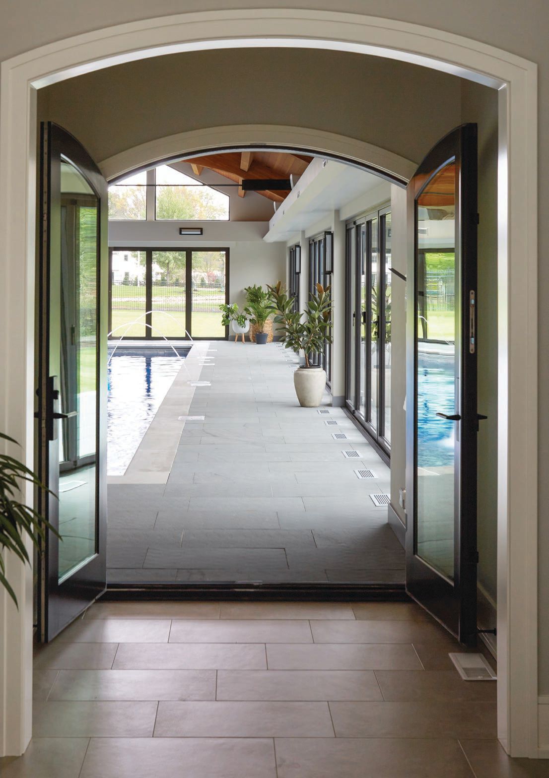 Striking archways add a touch of drama to the entrance of the pool house. Photographed by MICHAEL ALAN KASKEL