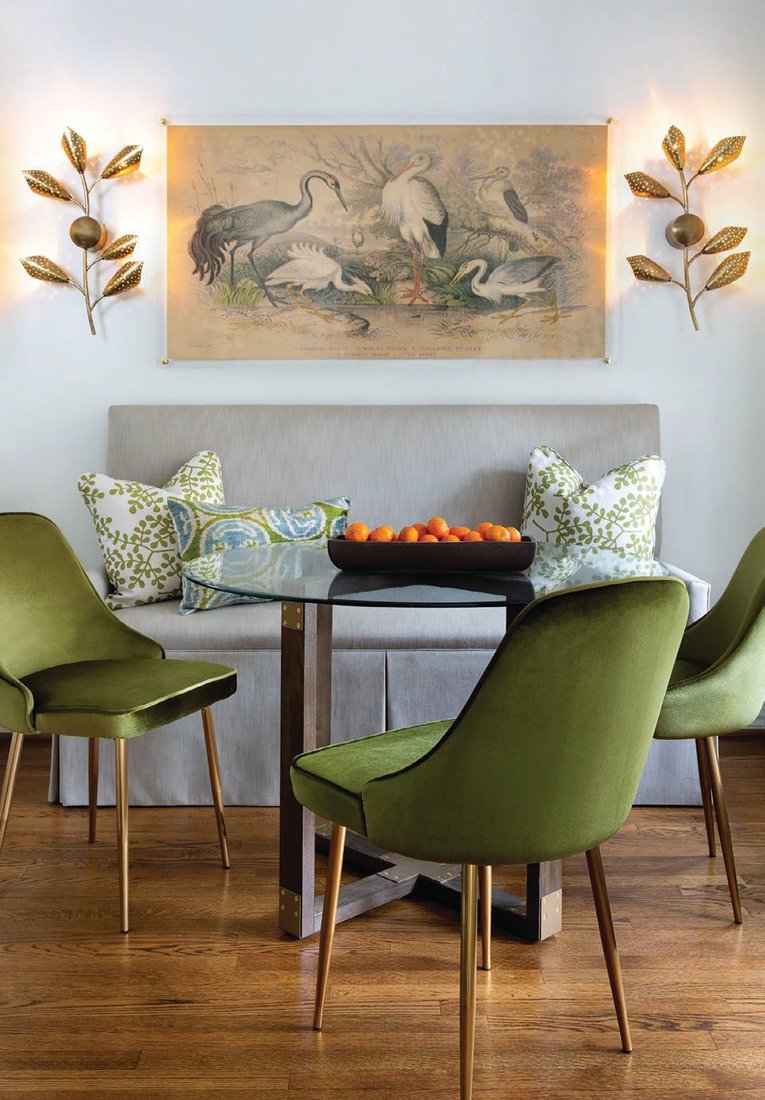 For this project in Houston, Jennifer Barron Design made a custom banquette bench to look like a piece of furniture to fit the space. The pops of green and pillows tie in with the kitchen window treatments and the glass table allowed for the space to feel bigger PHOTO BY MOLLY CULVER PHOTOGRAPHY