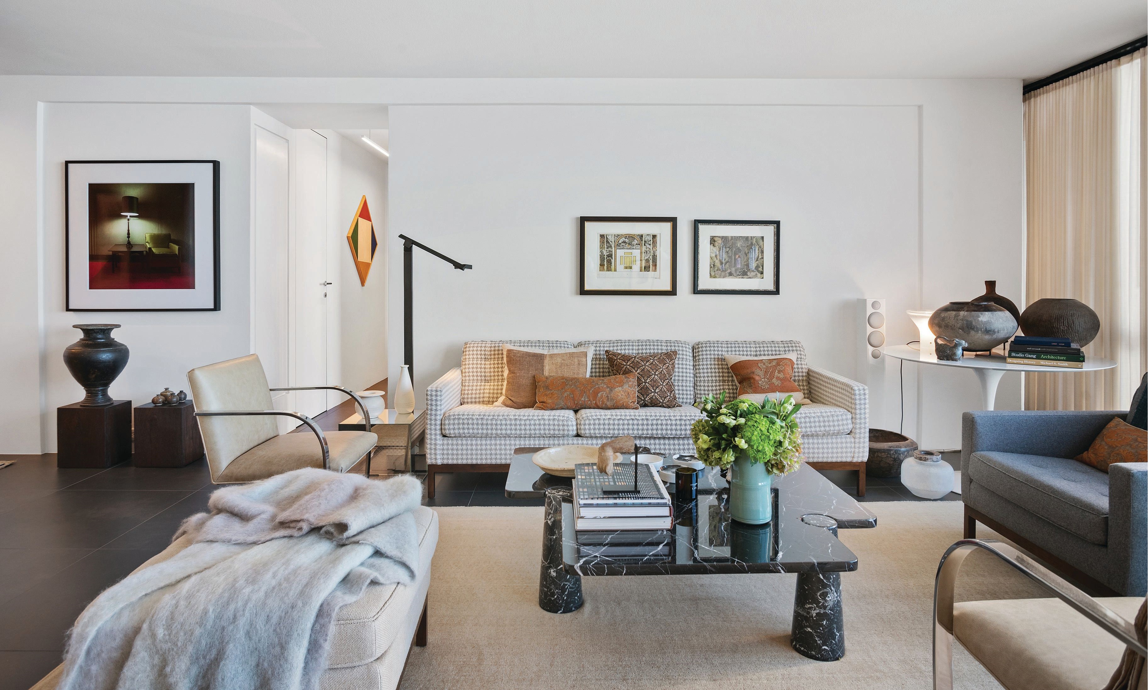 The living room serves as a sumptuous showcase of the client’s collection of art and antiques, including a vintage Angelo Mangiarotti coffee table; vintage Florence Knoll sofa, chair and ottoman; Glas Italia end table; and African pots sourced from Douglas Dawson Gallery. PHOTOGRAPHED BY PETRINI STUDIO