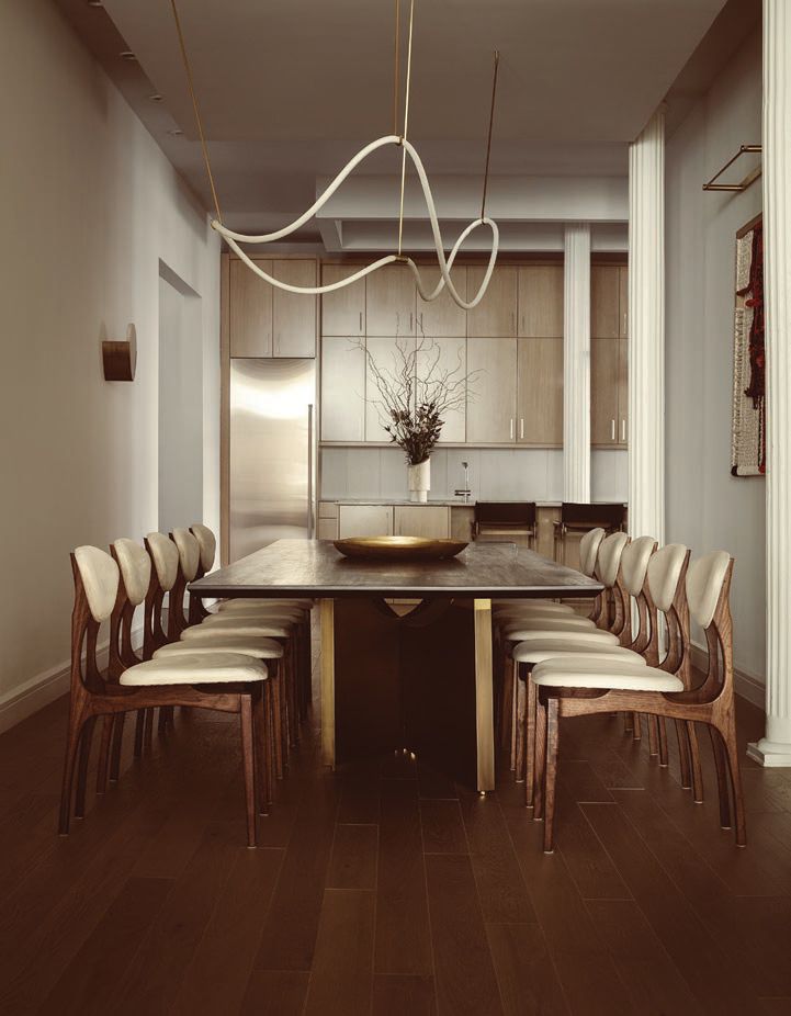 Sculptural art and lighting in the dining room and kitchen achieve the elevated, modern aesthetic the homeowners desired. PHOTO COURTESY OF ATRA
