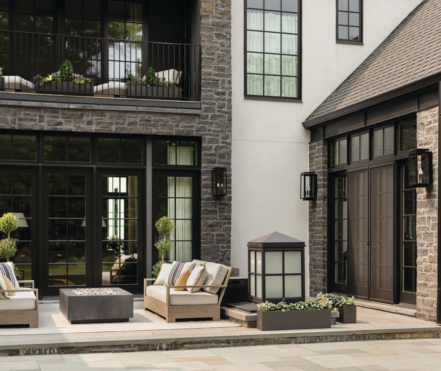The patio exudes charm with wallhung Frisco lights from Carolina Lanterns (Frisco model), custom floor-mounted lanterns by New Wave Creations and outdoor furniture from RH’s Provence collection Photographed by Aimée Mazzenga