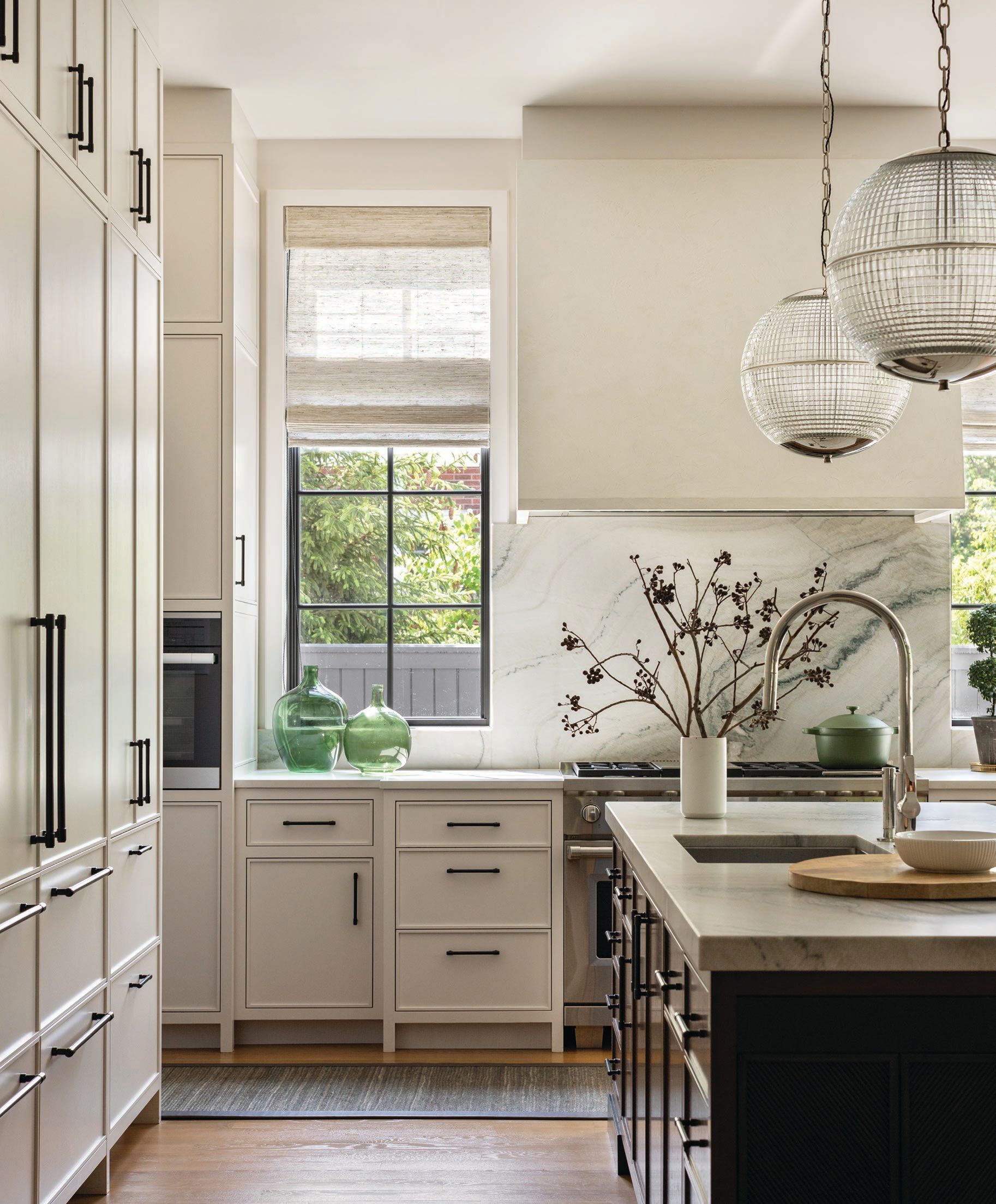 With sleek French ball globe pendants by Ann-Morris and cabinetry by New Style Cabinets, the kitchen is the picture of sophistication. Photographed by Aimée Mazzenga