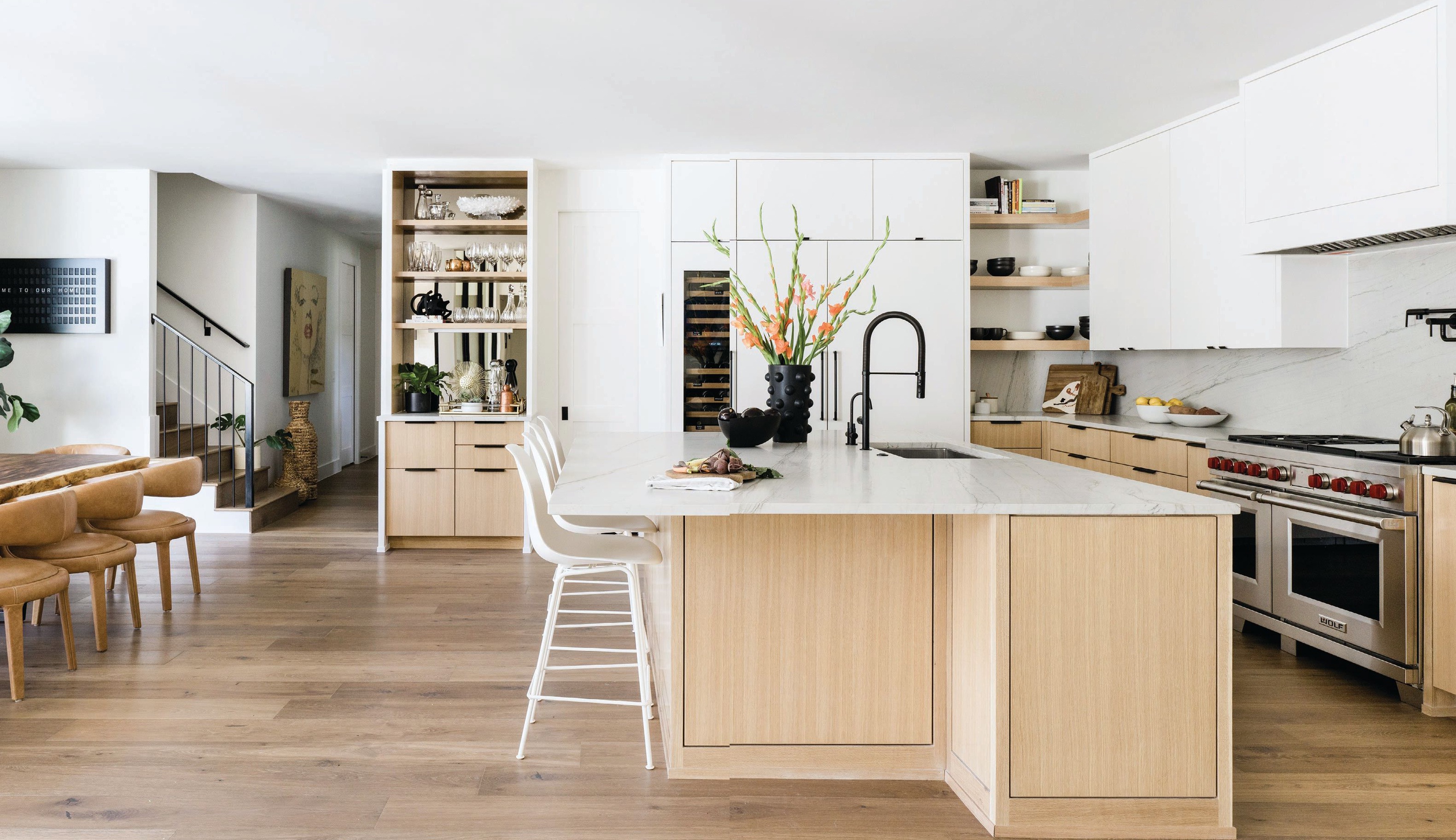 The spacious and airy kitchen features bar stools by DWR and modern cabinets by RiverCity Cabinets. PHOTOGRAPHED BY MADELINE HARPER