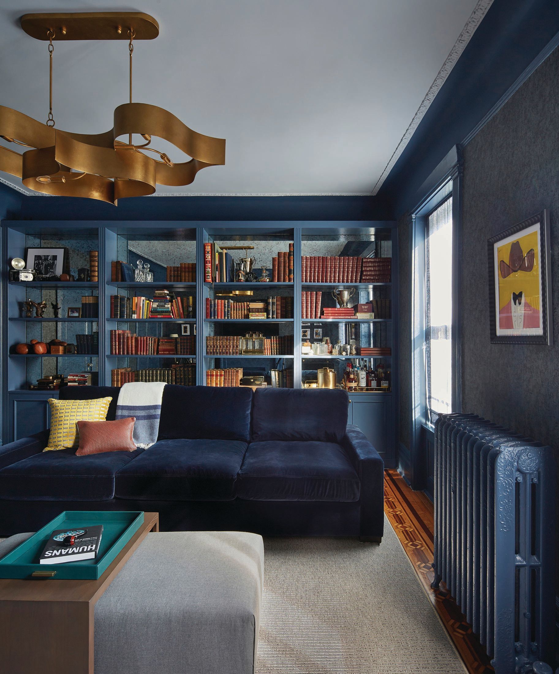 In the study, Phillip Jeffries wallpaper and an antique mirror inside existing bookcases. PHOTOGRAPHED BY JACOB SNAVELY