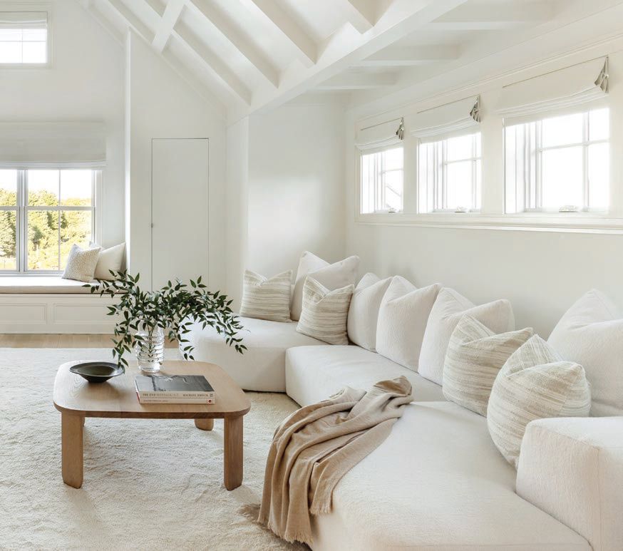 Bright white furniture and decor create an airy essence throughout the space Photographed by Regan Wood