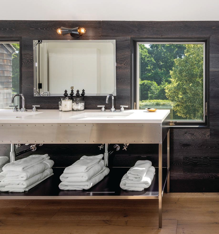 a custom MARKZEFF sink finished with stainless steel sits in front of black wood clapboarding with a pair of windows cut into it. PHOTOGRAPHED BY EVAN JOSEPH AND TIM WALTMAN