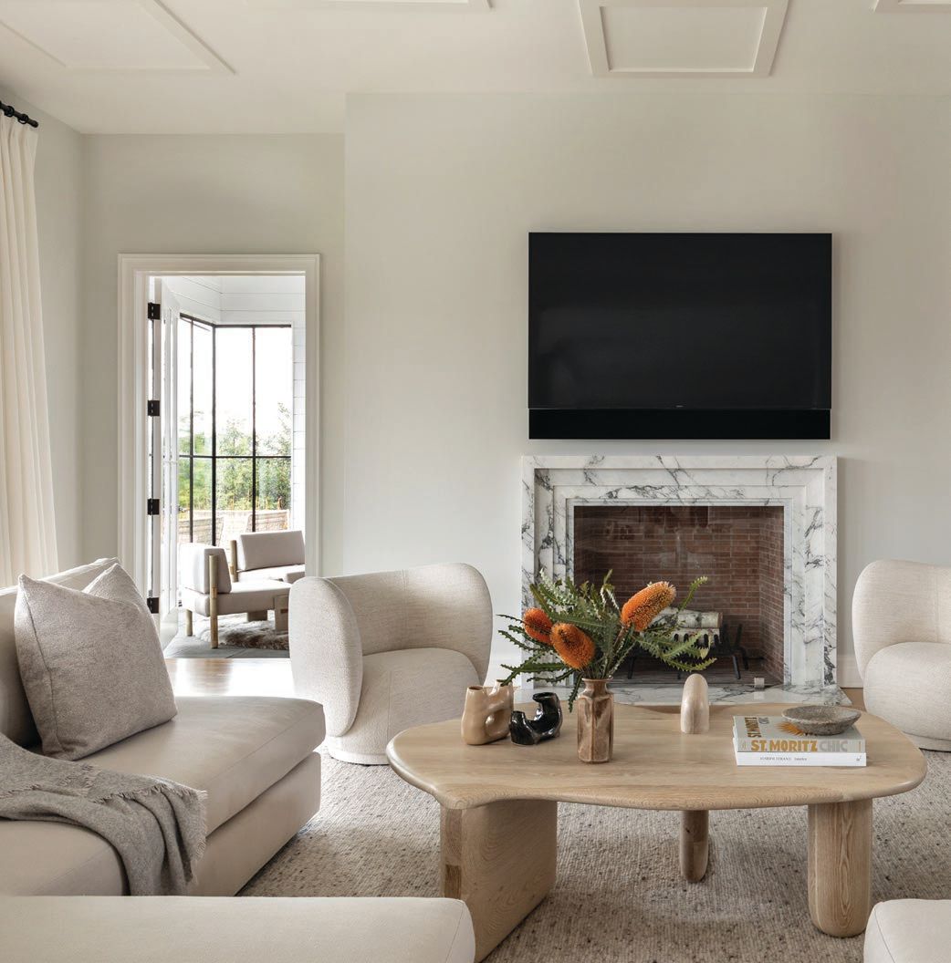 A marble accent around the fireplace complements the subdued design of the space. Photographed by Regan Wood