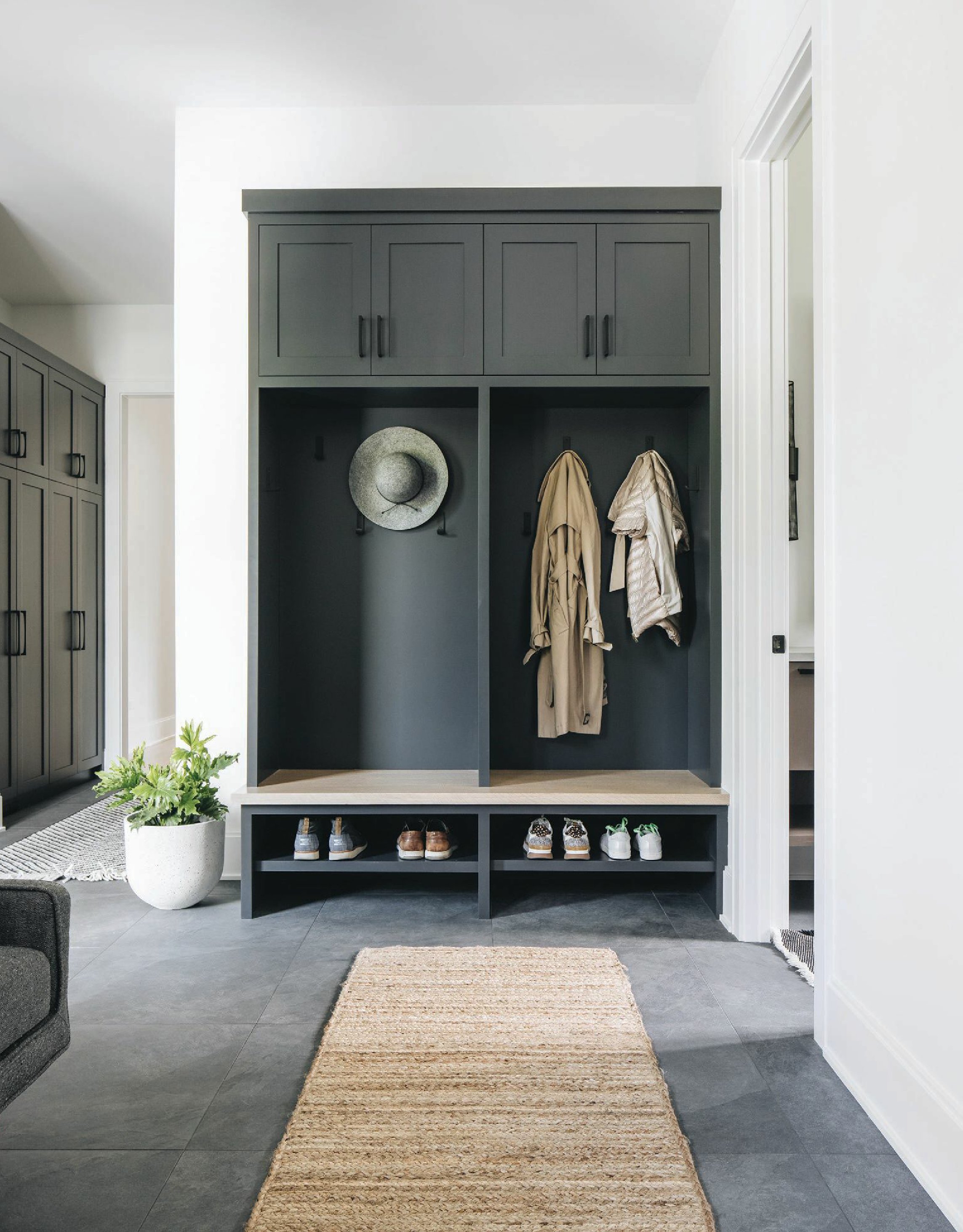 Custom cabinetry by Wood Quality Cabinets, tile by Virginia Tile and a jute rug by Amy Storm & Company make the mudroom pop. Photographed by Stoffer Photography Interiors