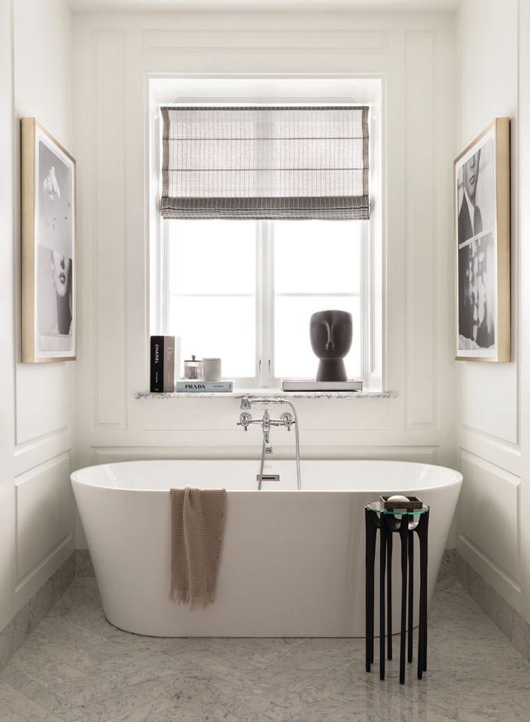 A slender side table from Global Views completes the serene scene in the primary bath Photographed by Aimée Mazzenga