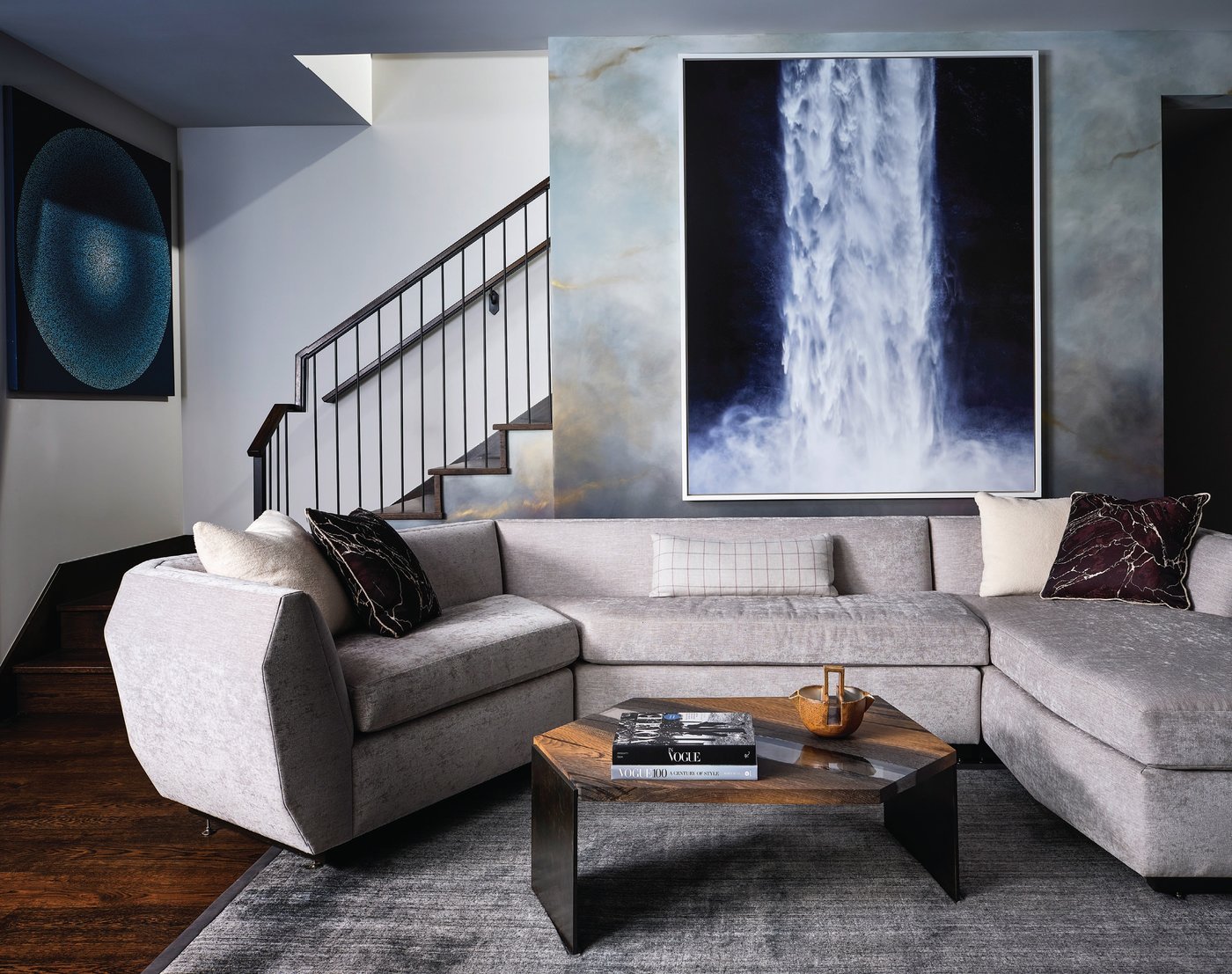 Artworks by Jonathan Smith (above the custom sofa) and A.J. Oishi bring an ethereal spirit to the downstairs media room. The rug is from Stark. PHOTOGRAPHED BY BRAD KNIPSTEIN