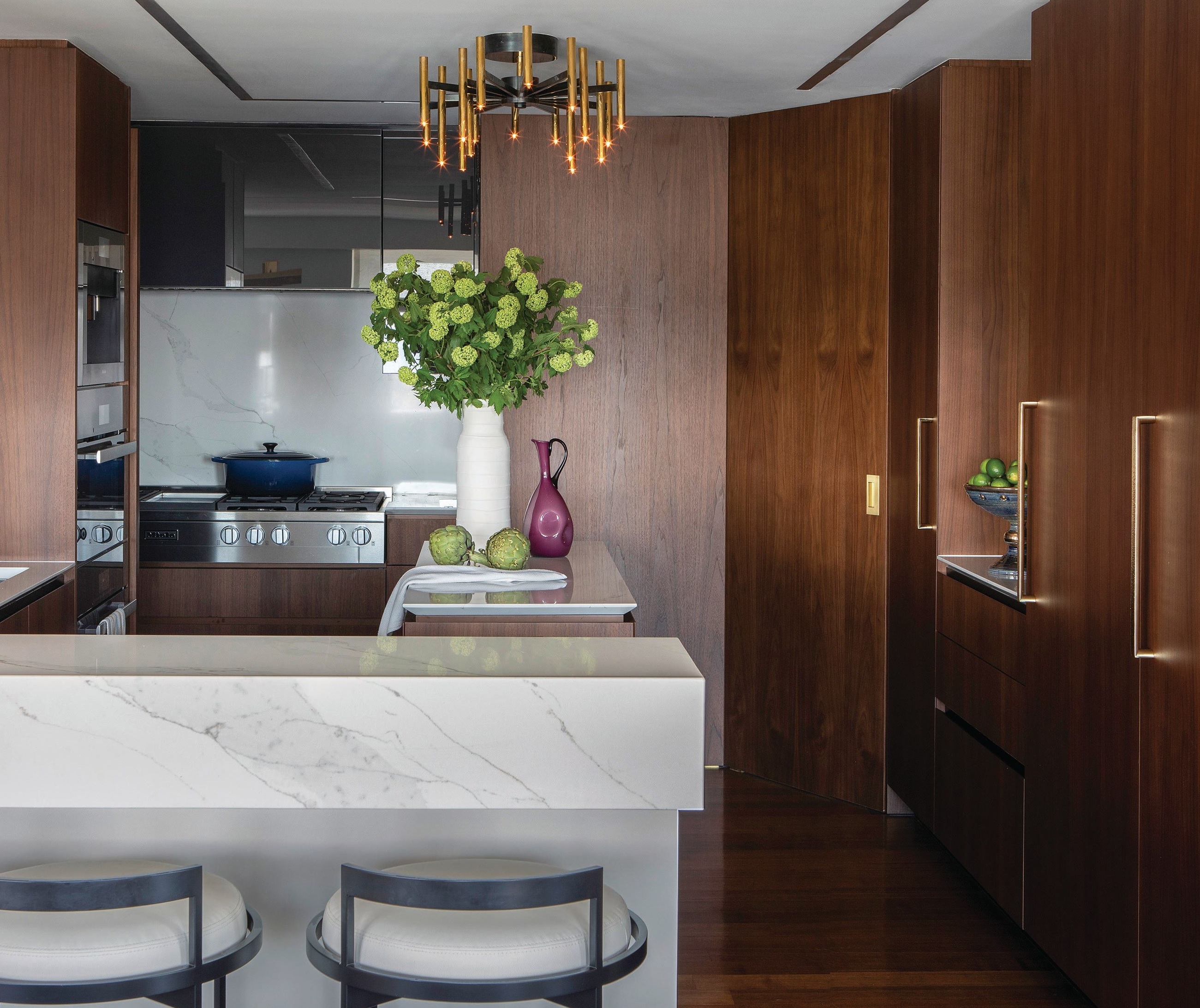 Poliform cabinets and Miele appliances complement a John Boone Inc. lighting fixture in the kitchen. Photographed by Costas Picadas