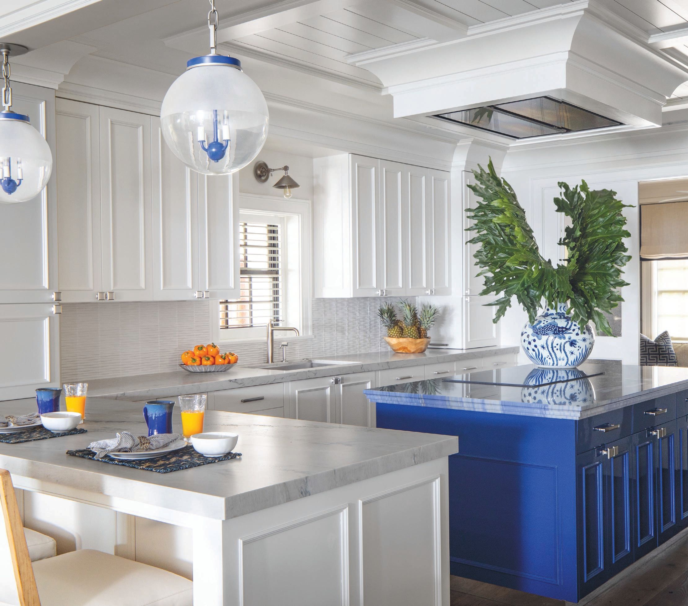 Urban Electric & Co. pendants take their blue cues from the vibrant island in the kitchen, painted in a high-gloss indigo from Sherwin-Williams Photographed by Wittefini