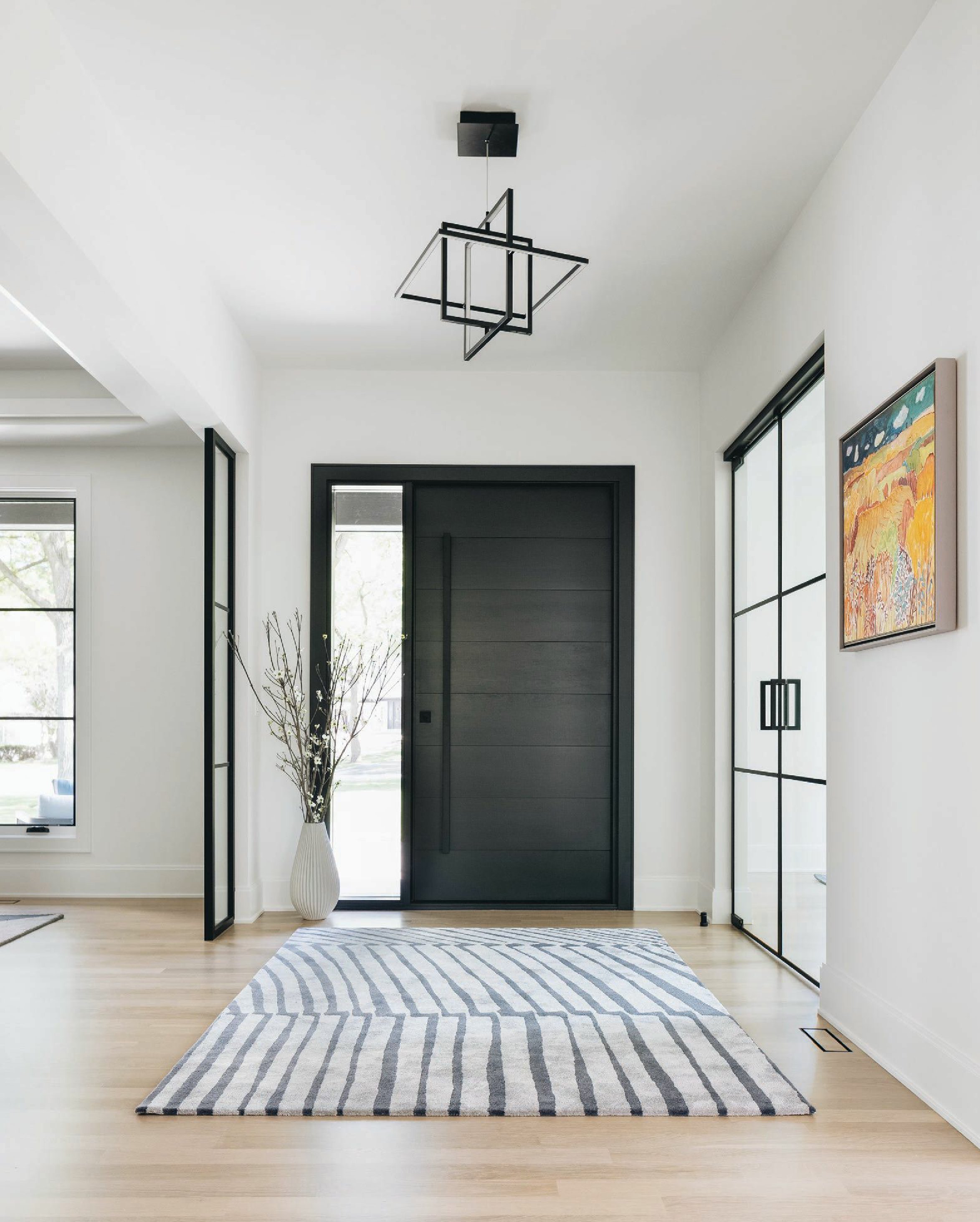 Highlights of the home’s entry include a Davis & Davis rug and Kuzco light fixture. Photographed by Stoffer Photography Interiors