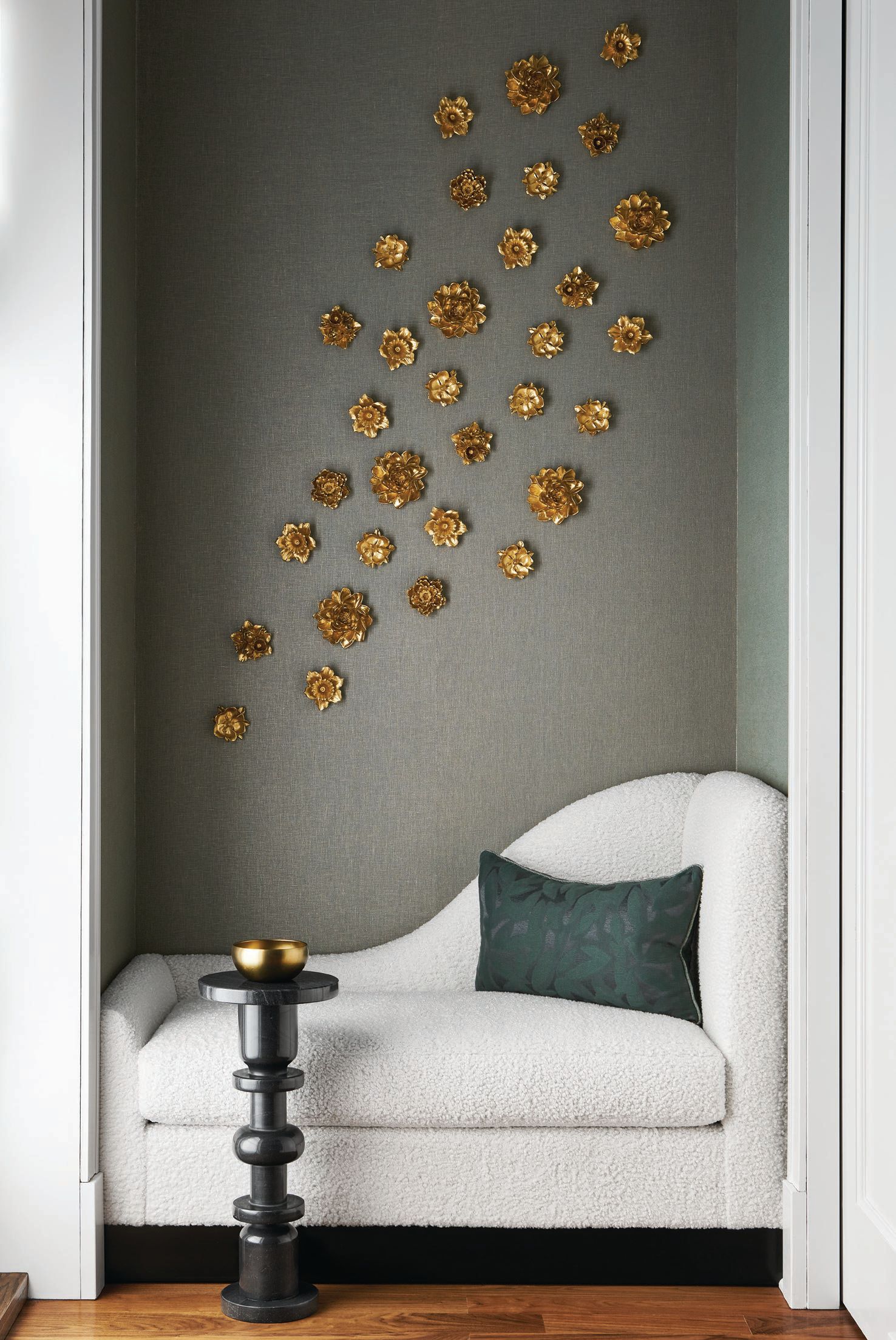 Perfectly filling a nook in the primary bedroom, a custom-designed built-in chaise fabricated by Eurocraft is accented with Holly Hunt Gossamer Luster wallcovering and—a lovely touch harking to the client’s Chinese heritage—a cluster of handmade flowers by Redwood Stoneworks (@redwoodstoneworks). PHOTOGRAPHED BY RYAN MCDONALD