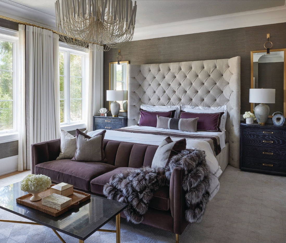 A custom winged tufted headboard upholstered in Holly Hunt beige suede fabric and a Tilda chandelier by Arteriors give the room grandeur Photographed by Werner Straube
