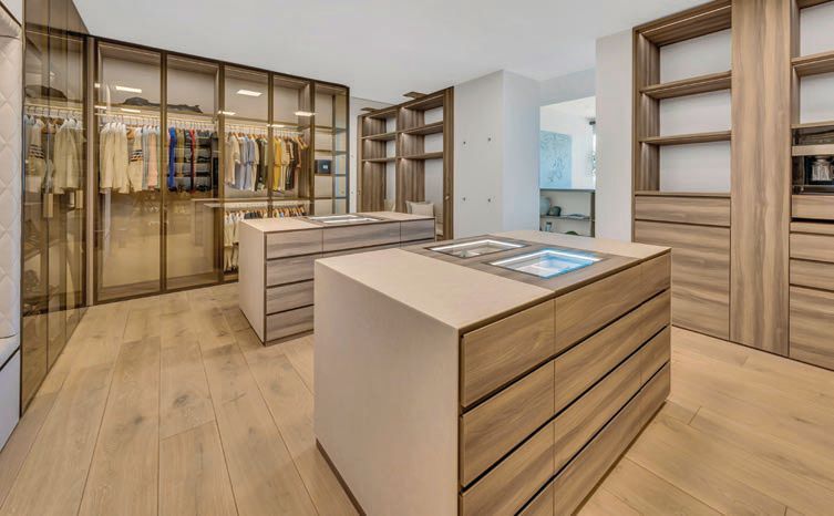 Twin islands, bronze-tinted glass and LED lighting were utilized in the primary closet. PHOTO COURTESY OF THE OPPENHEIM GROUP