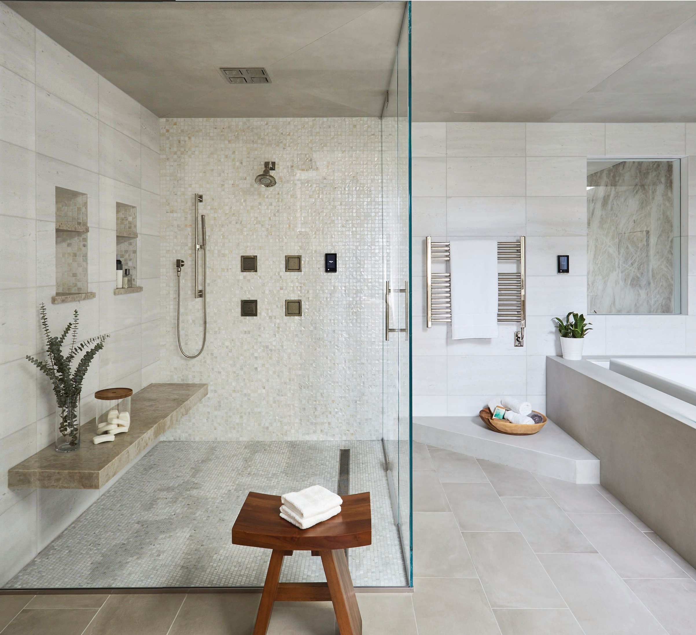 The capacious primary bath features a chic Kohler tub with waterfall edge. Photographed by MICHAEL ALAN KASKEL