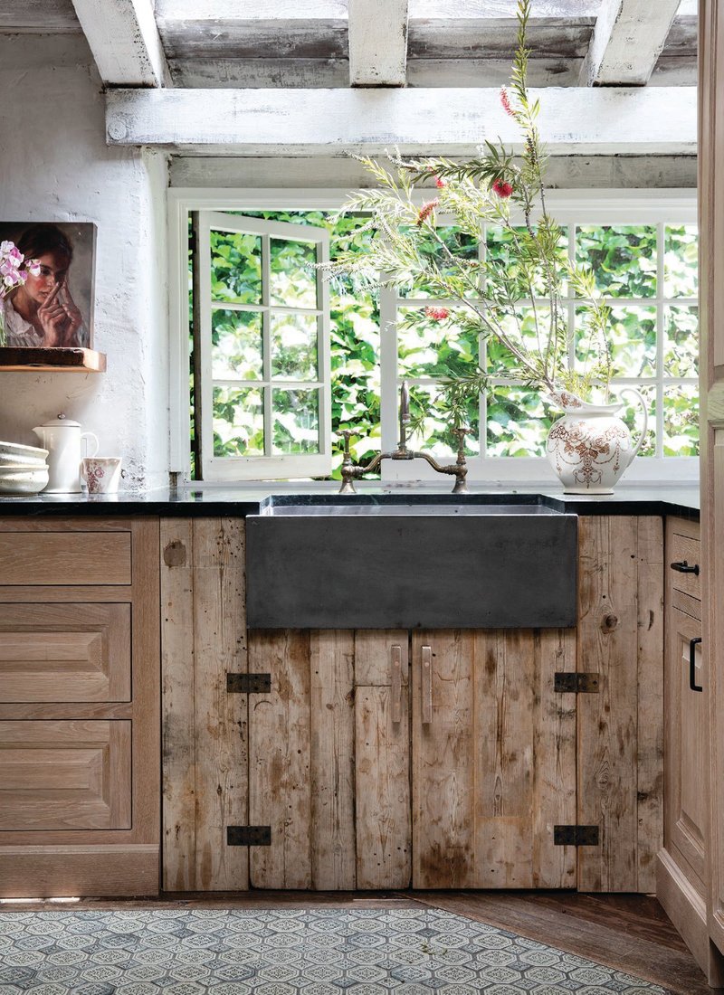 Native Trails’ Farmhouse 3018 sink in slate by a sunlit window in a kitchen designed by Leanne Ford Interiors. PHOTO BY AMY NEUNSINGER.