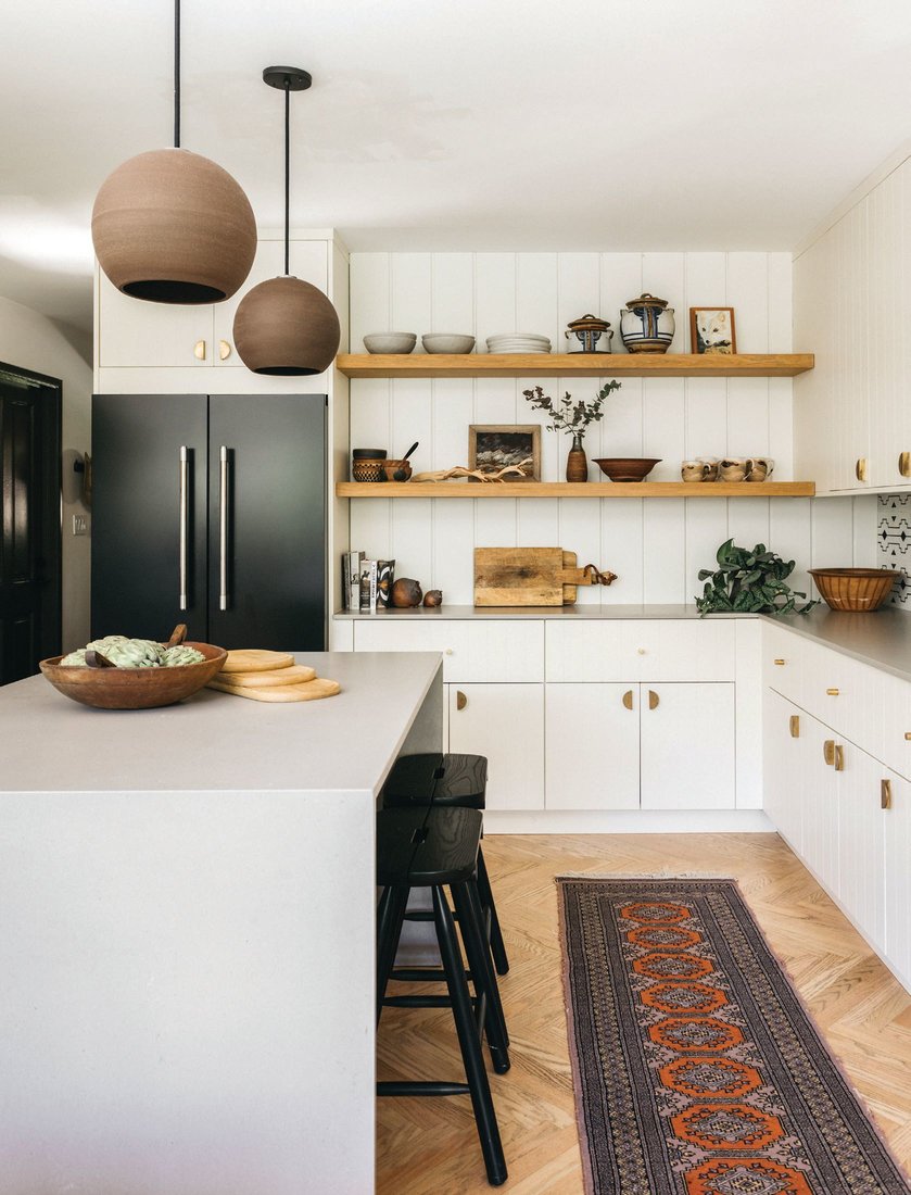 Rejuvenation pendants hover over the kitchen lined with cabinets by Semihandmade. PHOTOGRAPHED BY ALEX ZAROUR, VIRTUALLY HERE STUDIOS