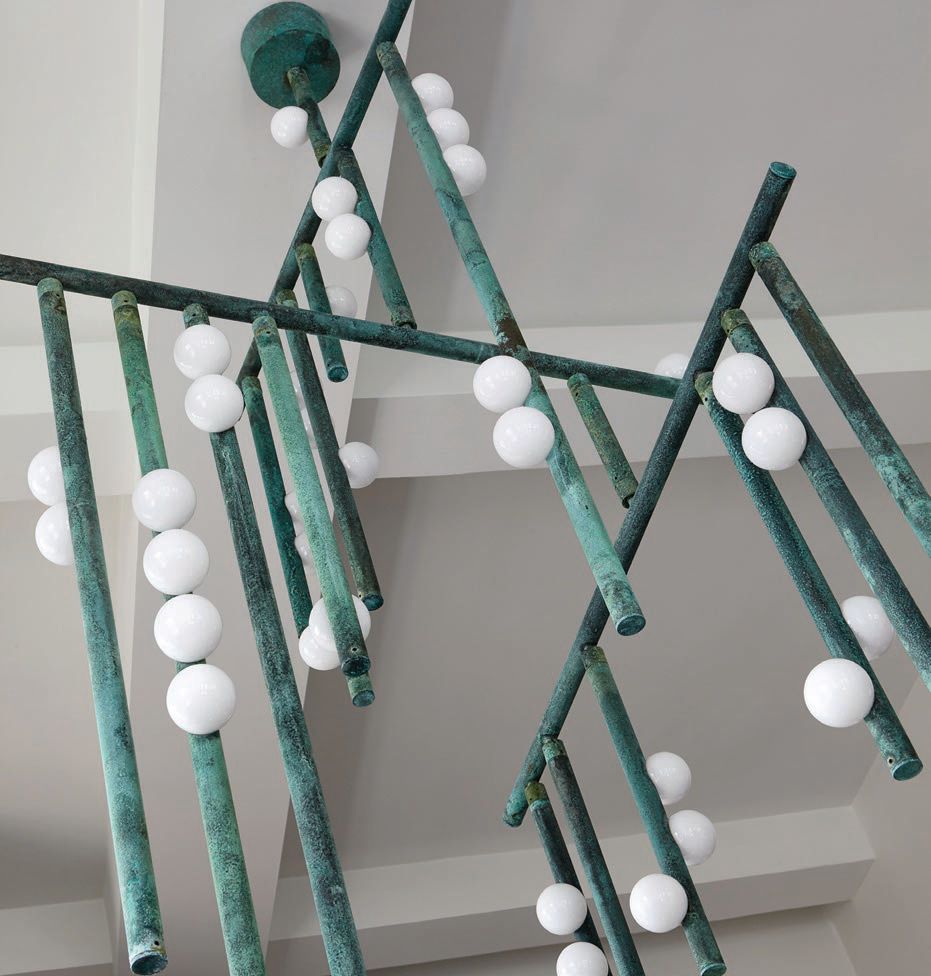 A custom drop system chandelier by Lindsey Adelman in Verdigris finish in the dining room Photographed by Joshua McHugh