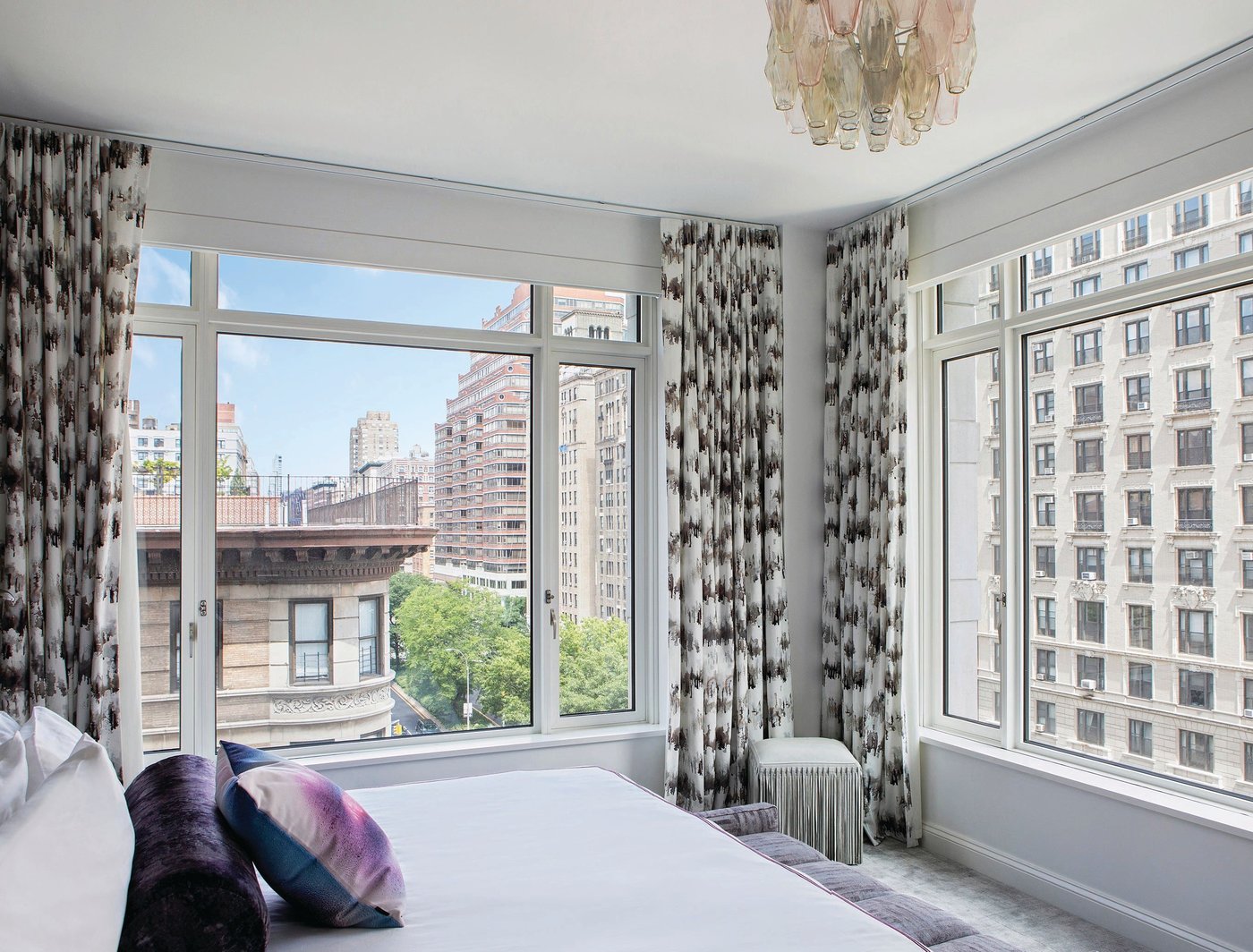 A modernist handblown Murano polyhedral chandelier from High Style Deco in NYC and Romo Fabric window treatments in the primary bedroom Photographed by Costas Picadas