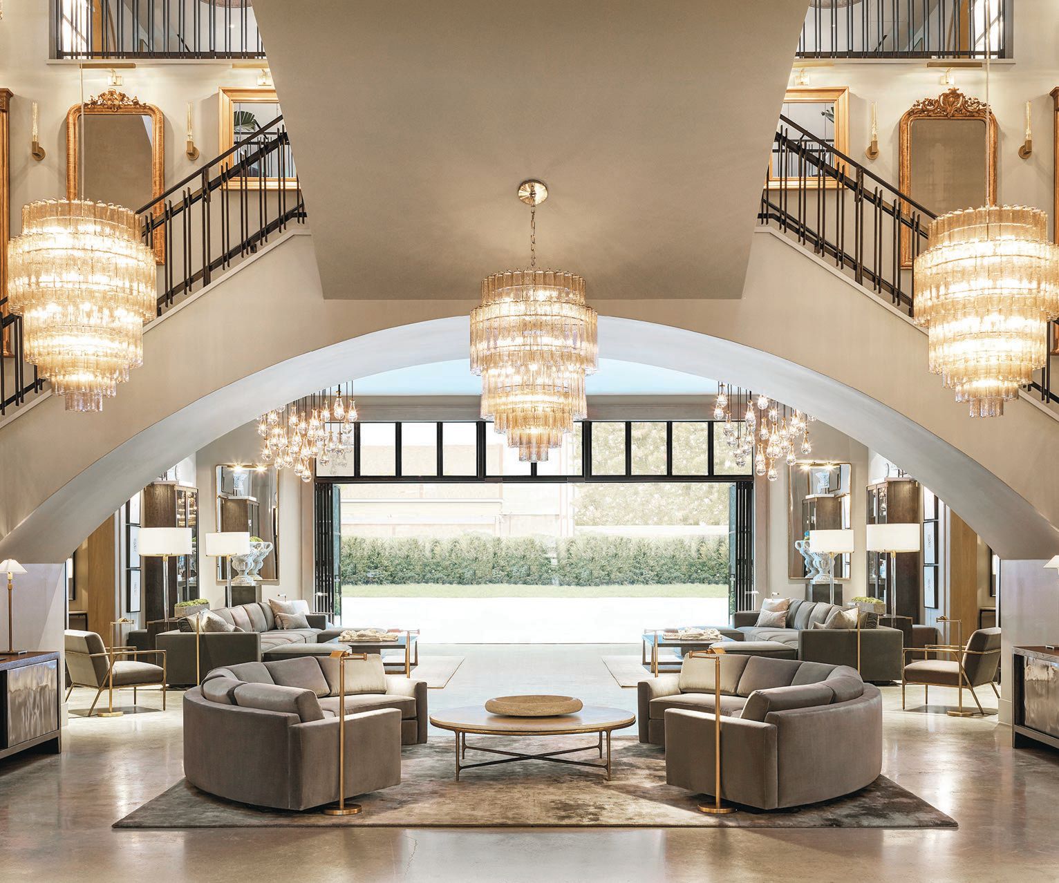 The great room features a grand staircase, chic chandeliers and a relaxing lounge area. PHOTO COURTESY OF RH OAK BROOK